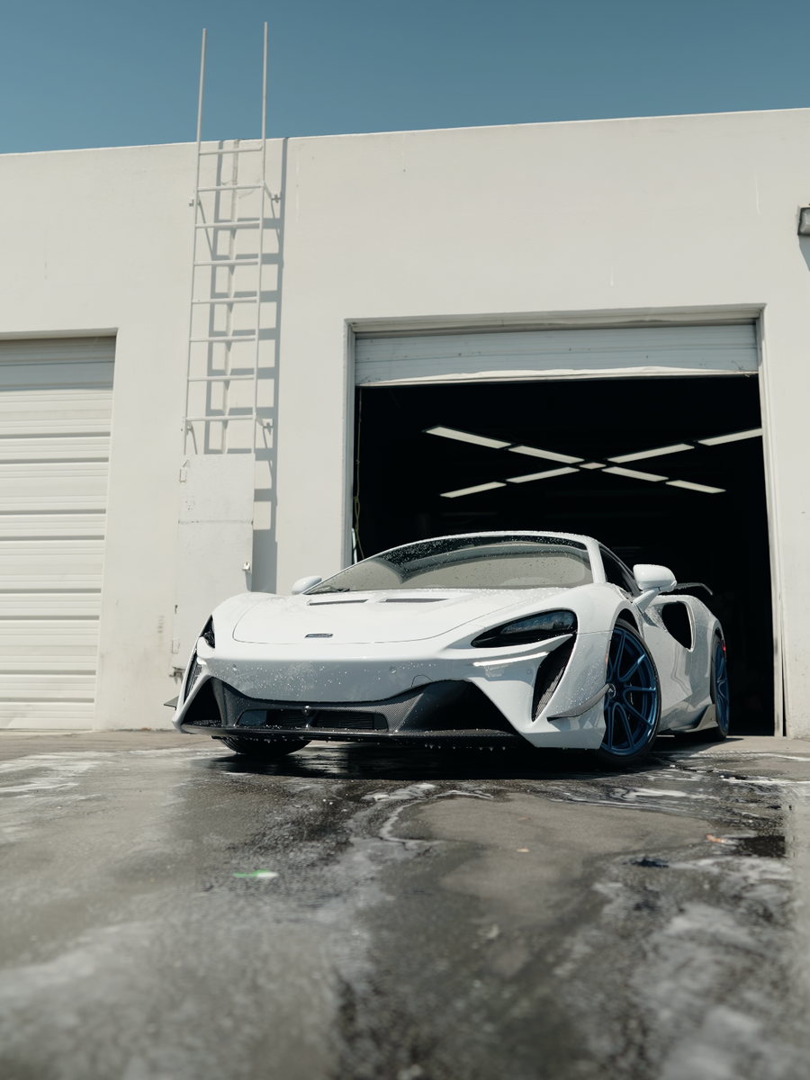 A freshly washed supercar rolled out of the bay onto wet pavement.