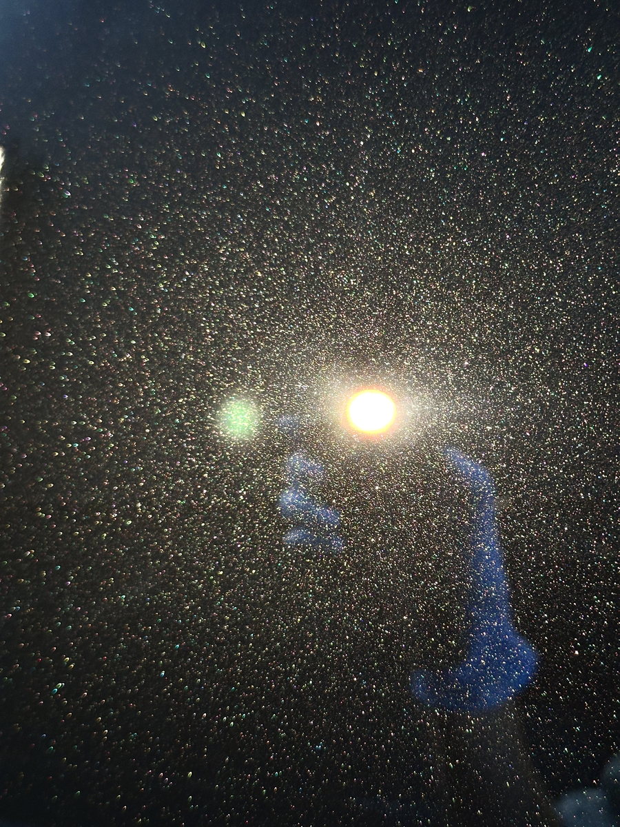 Paint under a focused inspection light, showing the fine swirls a correction removes.